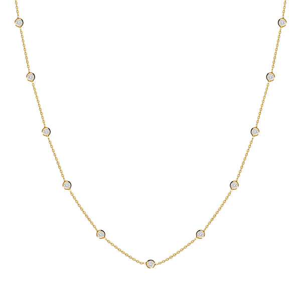 This delicate 14 karat gold necklace is handmade and features sparkling bezel - set stones. Diamond gold necklace.