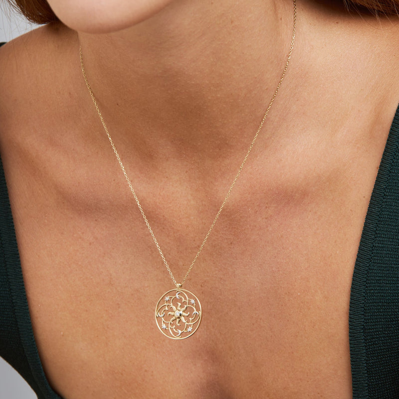 Yellow Gold, White Gold and Diamonds. The 14 karat gold pendant necklace is a representation of the galaxy with the bright sun in the centre.  This handmade diamond pendant features handset diamonds with the moon and stars accentuated in white gold. A beautiful jewelry piece that lasts a lifetime.