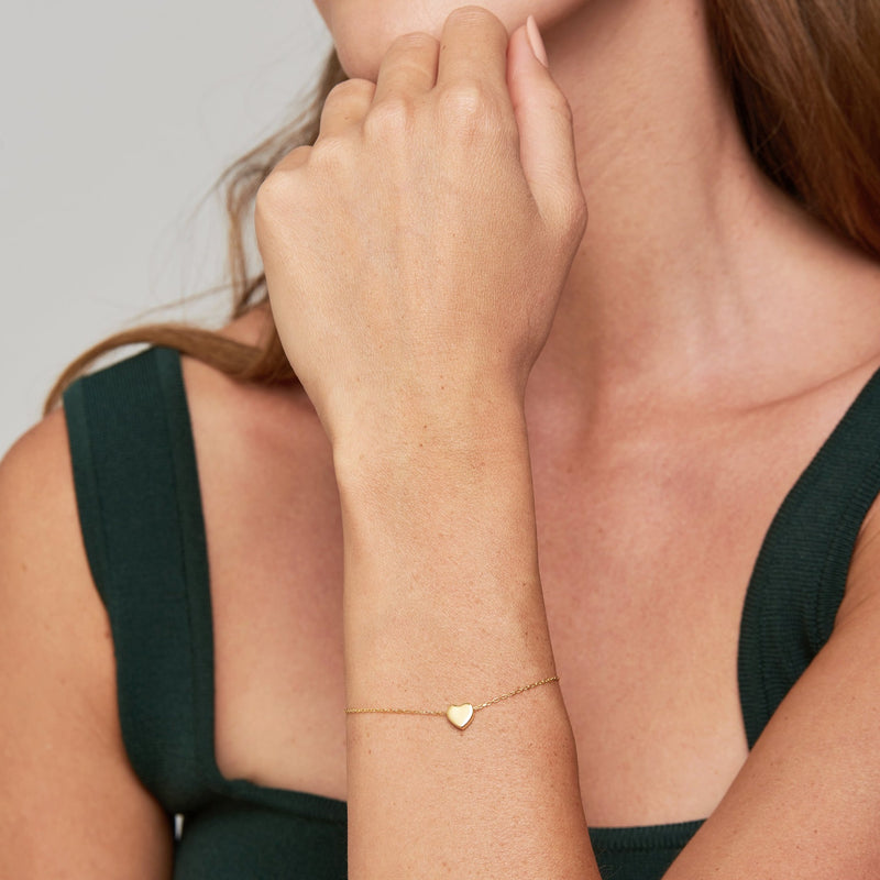 A delicate gold heart bracelet for day to day wear. This subtle design of the heart pendant is double sided, which means that it can twist and turn and always reveal its beautiful sides of the pendant.